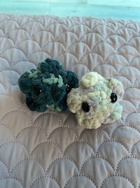 two crocheted clouds on top of a quilt